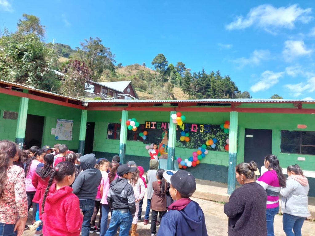 The school building at Aldea El Socorro with children gathered outside